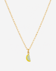 Eine Goldkette mit einem kleinen Anhänger in Form einer Zitronenscheibe, verziert mit gelbem und hellgrünem Emaille. Dieser „Zitronen-Charm-Anhänger“ ist ein verspieltes Schmuckaccessoire, das auf der Kette vor einem schlichten weißen Hintergrund perfekt zentriert ist.