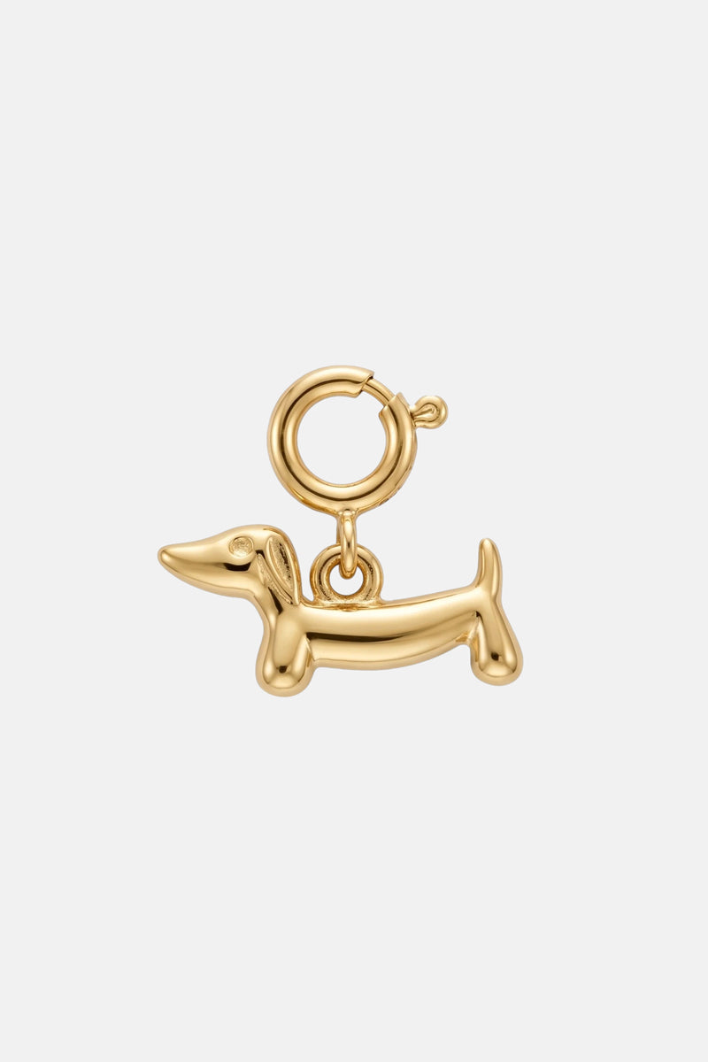 Ein goldfarbener Dackel-Anhänger von Princess Goes Hollywood in Form eines Dackels mit rundem Verschluss. Dieser Edelstahl-Anhänger hat einen glatten Kopf, einen glatten Körper, glatte Beine und einen glatten Schwanz – ein elegantes Schmuckgeschenk vor einem schlichten weißen Hintergrund.