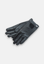 A pair of Princess Goes Hollywood gloves rests on a light gray surface, displaying chevron-stitched leather, a small black wrist patch, and a metallic snap button closure for a sleek, fitted look.