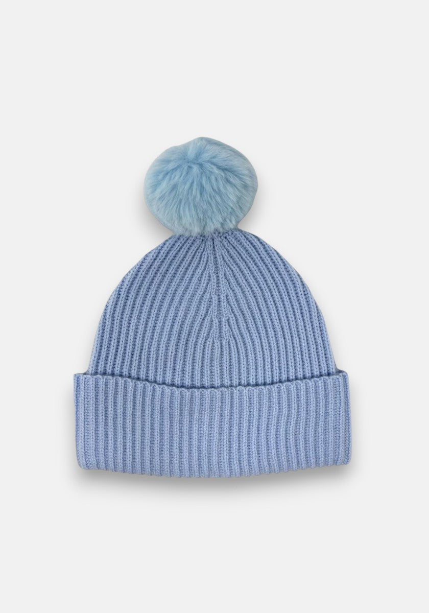 A light blue ribbed beanie with a folded brim and a large, fluffy pompom on top by Princess Goes Hollywood, shown against a plain white background.