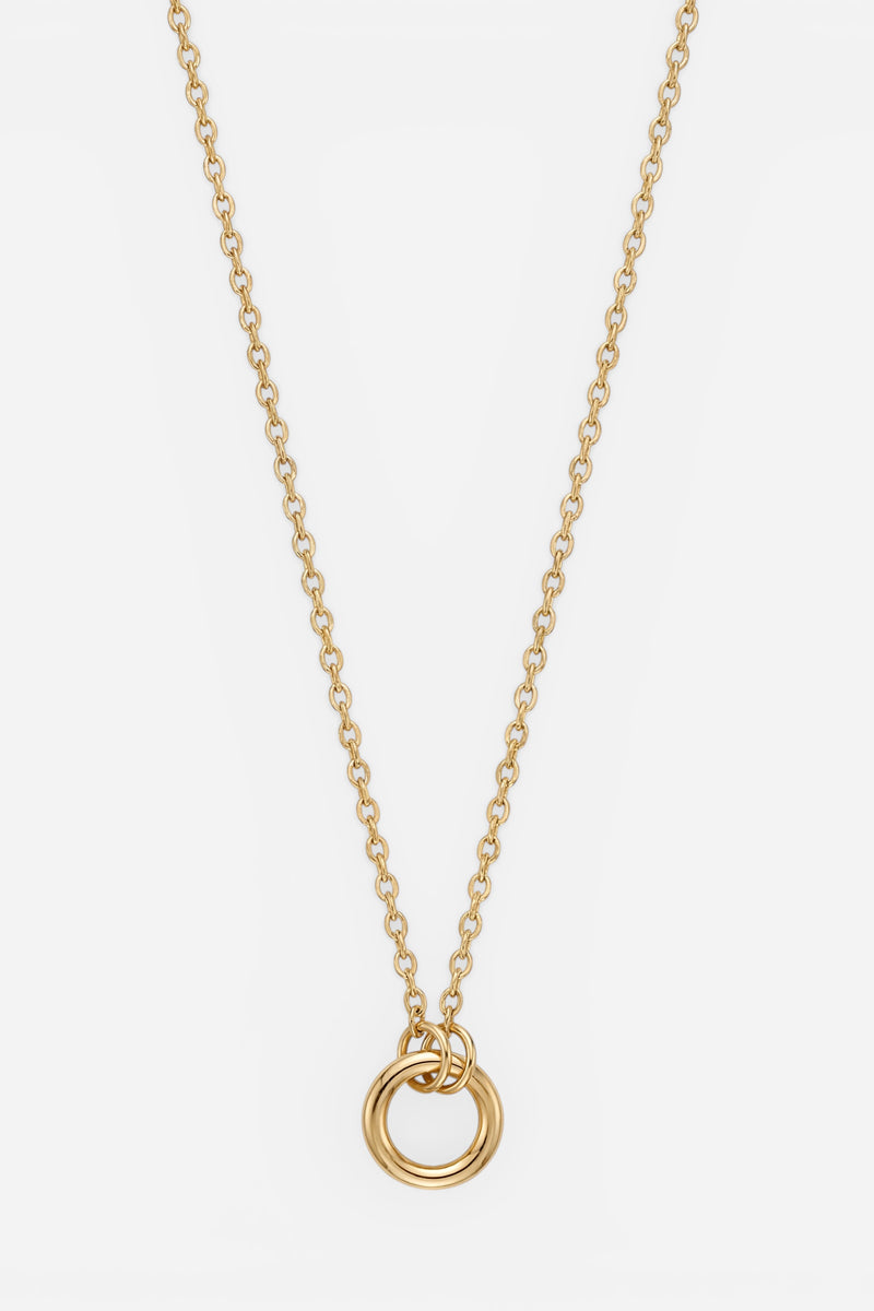 Die „The Princess Goes Hollywood“-Charm-Gliederkette mit 18-karätiger Vergoldung besteht aus kleinen, gleichmäßig angeordneten Gliedern und ist mit zwei glatten, polierten, ineinander verschlungenen Goldringen als Anhänger verziert, die vor einem weißen Hintergrund einen minimalistischen und eleganten Look erzeugen.
