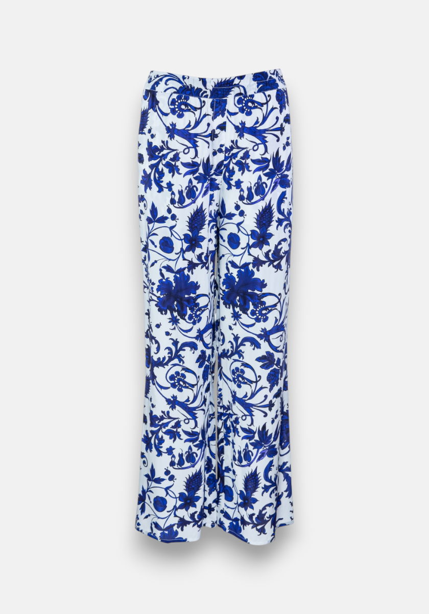 Princess Goes Hollywood presents a white wide-leg lockere Hose with vibrant blue Blumenprint and elastischem Bund. The floral and vine pattern covers the entire garment, offering a striking look on a crisp white background.