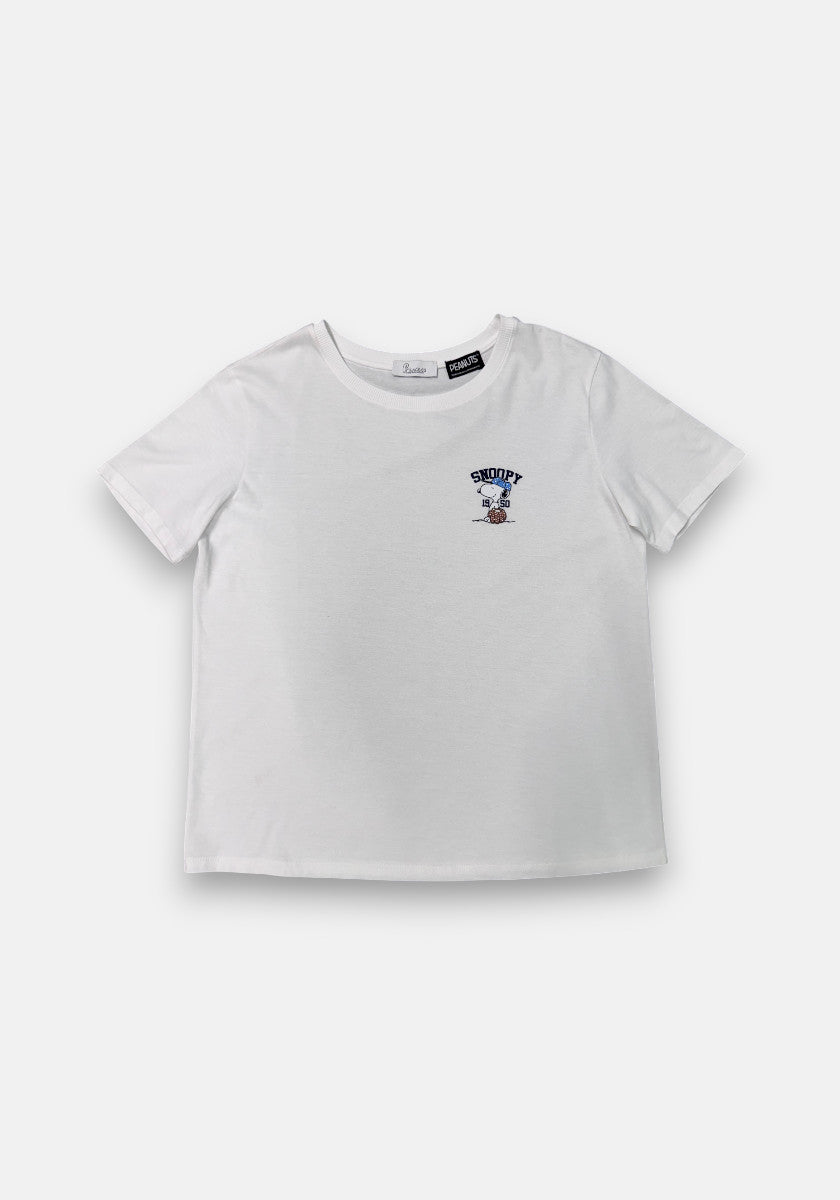 A Princess Goes Hollywood white short-sleeve t-shirt is displayed flat on a white background. The left chest has a small “SNOOPY” graphic in blue above Snoopy standing, marking the Peanuts 75th Anniversary.