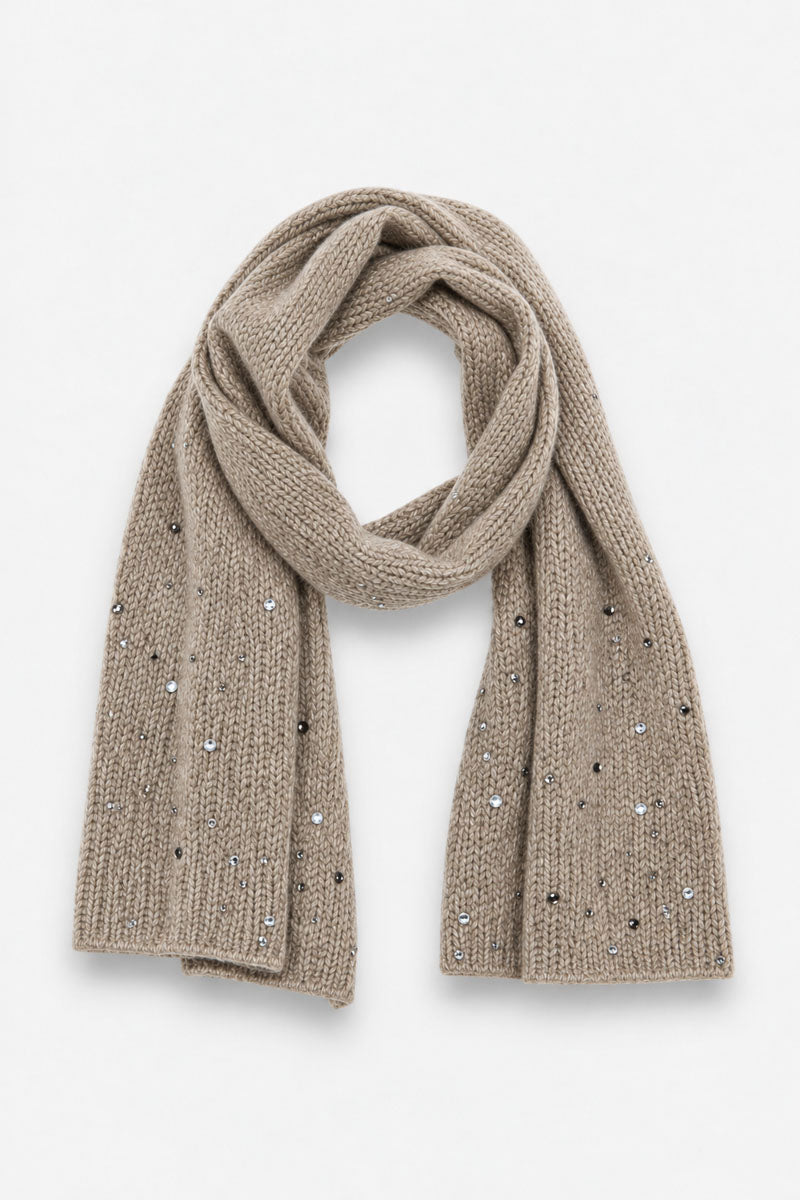 Ein hellbrauner Strickschal aus einer Merino-Kaschmir-Mischung, der locker vor einem weißen Hintergrund drapiert ist und mit vereinzelten silbernen Nieten sowie klaren Strasssteinen verziert ist, die für eine dezente Strassverzierung sorgen.