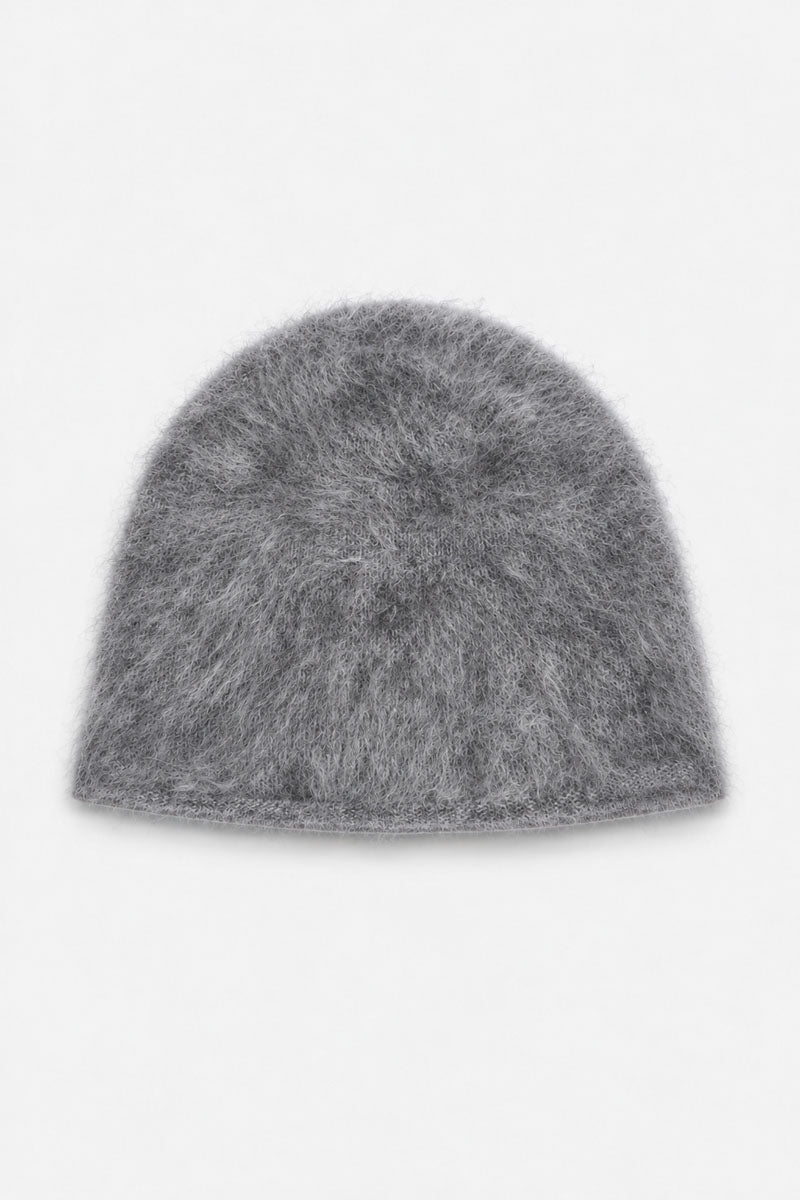 Eine graue, gebürstete Kaschmir-Mütze aus flauschigem, mohairähnlichem Material ist mittig auf einem schlichten weißen Hintergrund abgebildet. Die Strickmütze hat eine abgerundete Krone und eine schlichte, nicht umgeschlagene Krempe.