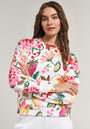 A woman with long brown hair models a Princess Goes Hollywood floral strawberry print Sweatpullover with a crew neck. She stands arms crossed, looking at the camera, styled with white pants and subtle jewelry against a plain background.