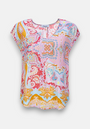 This Princess Goes Hollywood short-sleeve blouse features a vibrant ornament print in pink, orange, yellow, blue, and white. Made from high-quality silk with a round neckline and relaxed fit—ideal for warm weather.