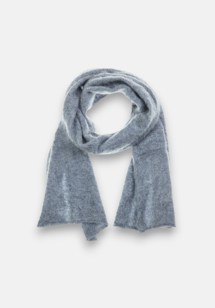 A soft, light gray Princess Goes Hollywood Kaschmir Schal is loosely looped with both ends hanging down. The fuzzy gebürstetes Kaschmir stands out warmly against a clean white background, highlighting the scarf as the image’s focal point.