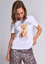 A woman with light brown hair wears a weiße Baumwolle T-Shirt mit Rundhalsausschnitt von Princess Goes Hollywood, das ein flauschiges orangefarbenes Kätzchen und “PRINCESS” zeigt. Sie kombiniert es mit Luchs-Print-Hose vor hellem Hintergrund.
