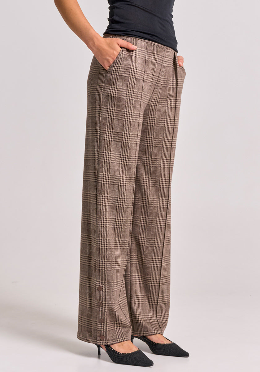 A person, shown from the waist down against a neutral background, wears brown-and-beige checked wide pants with elastic waistband by Princess Goes Hollywood, paired with a fitted black top and black pointed shoes. Hands are in pockets.