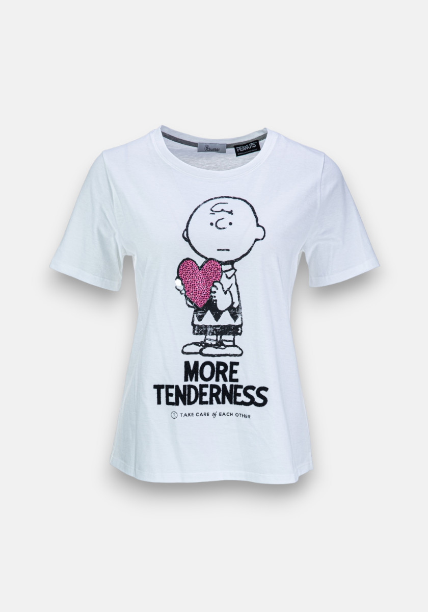 A white Princess Goes Hollywood Baumwolle T-shirt with short sleeves shows a black outline of Charlie Brown holding a pink sequined heart, with "MORE TENDERNESS" and "TAKE CARE of EACH OTHER" in black below.