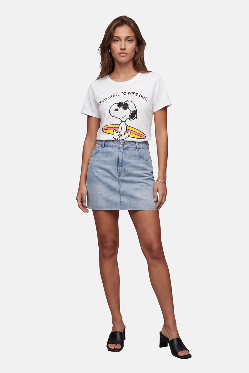 Vor einem schlichten weißen Hintergrund steht eine Frau in Freizeitkleidung mit Blick nach vorne. Sie trägt ein T-Shirt von Frogbox by Princess Limited Edition mit Snoopy-Aufdruck und der Aufschrift „Too Cool to Wipe Out“, einen hellblauen Jeans-Minirock sowie schwarze Sandalen mit offener Spitze und Absatz.