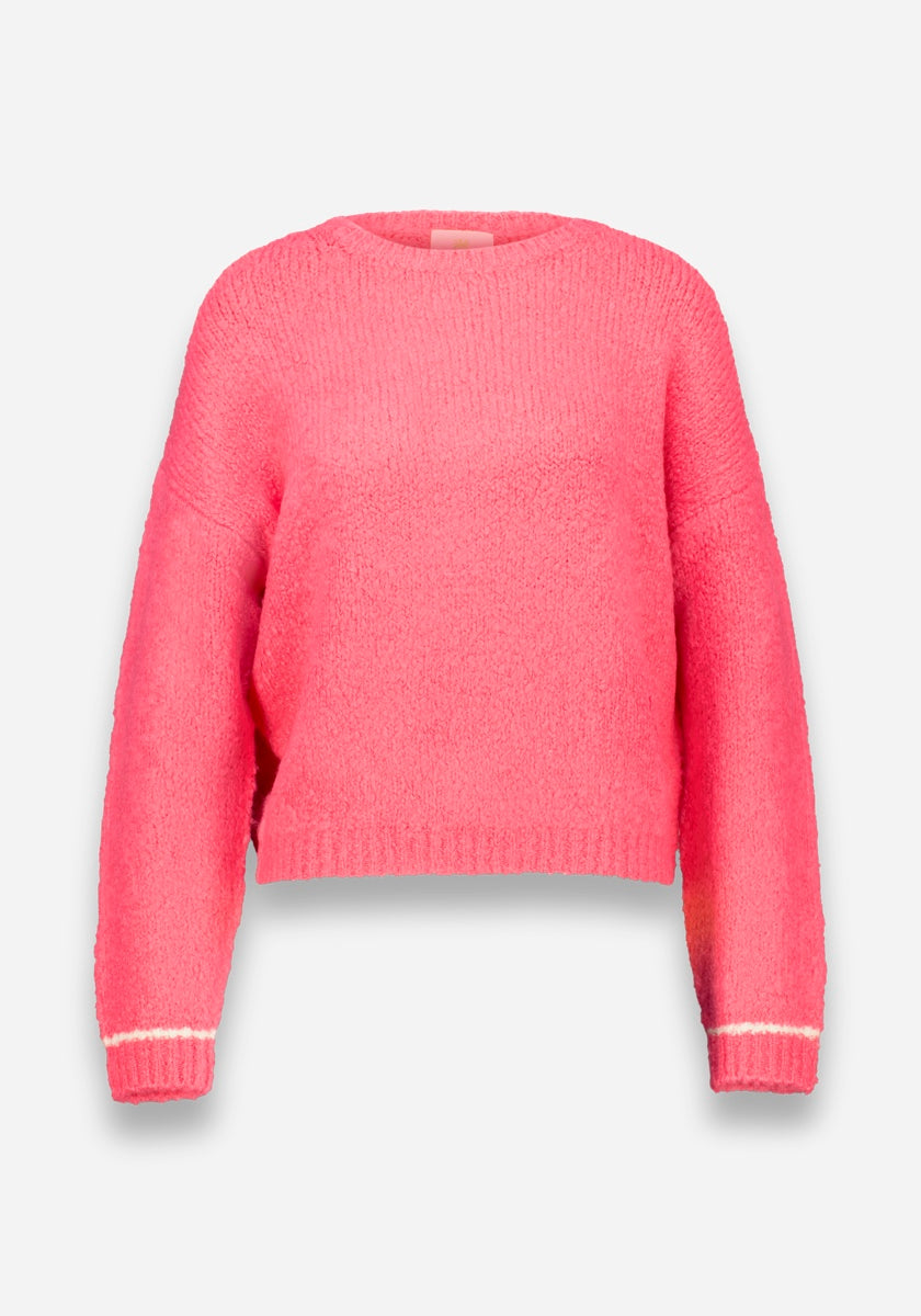 Ein leuchtend pinker Damen Grobstrickpullover von Princess Goes Hollywood mit langen Ärmeln, Rundhalsausschnitt, dünnen weißen Streifen an den Bündchen, dezenter Rippung und einer leicht kastigen Passform. Auf einfarbig weißem Hintergrund.