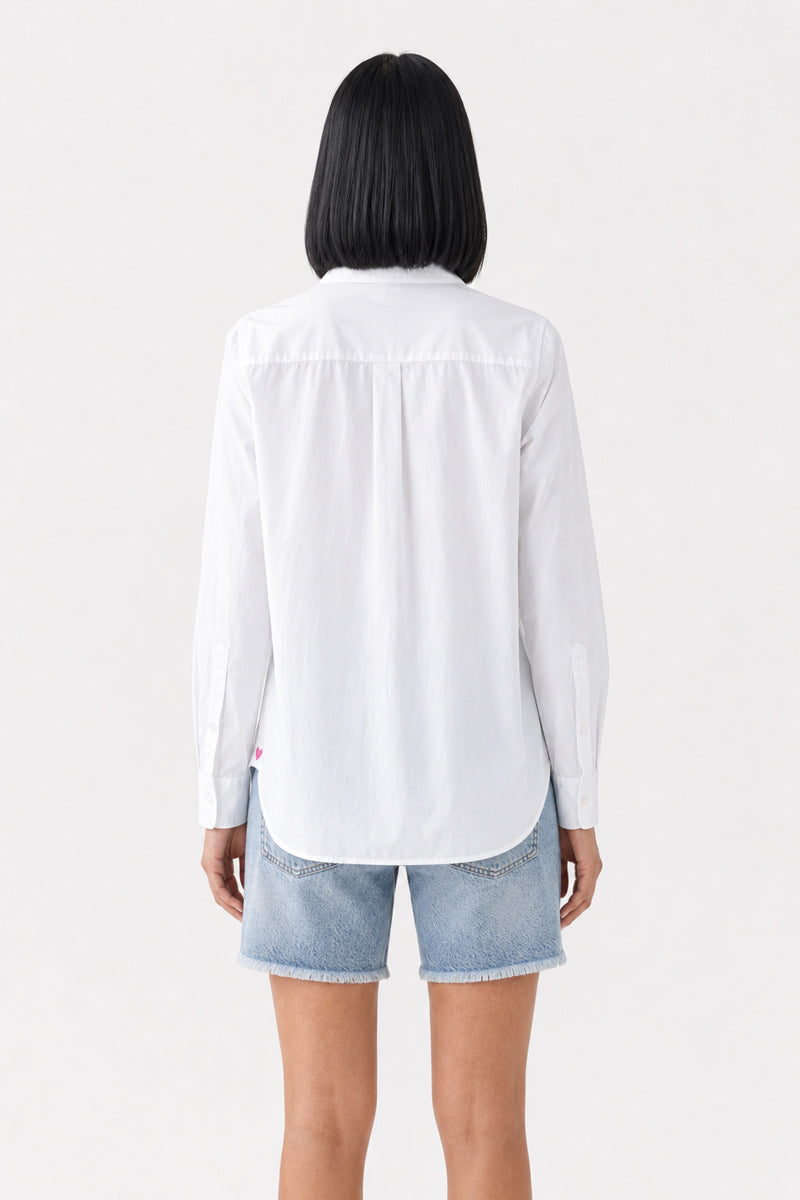 Eine Person mit glattem, schulterlangem schwarzem Haar steht mit dem Rücken zur Kamera und trägt eine weiße, langärmelige Baumwoll-Hemdbluse von „Princess Goes Hollywood“ sowie hellblaue Jeansshorts. Der Hintergrund ist schlicht weiß.