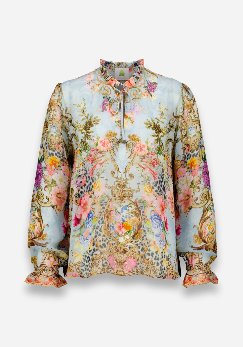 Eine langärmelige Seidenbluse von Princess Goes Hollywood mit Rüschen an den Manschetten und am Kragen, die einen verzierten mehrfarbigen Blumen- und Barockdruck auf hellblauem Grund zeigt, der mit Leopardenmuster akzentuiert ist und einen zarten, romantischen Look erzeugt.