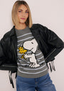 Eine Frau mit blondem Bob trägt eine schwarze Lederjacke über einem grauen Princess Goes Hollywood Baumwollmix-Pullover mit einer auffälligen Snoopy-Woodstock-Grafik. Sie ist mit Blue Jeans gestylt und posiert selbstbewusst vor einem hellen Hintergrund.