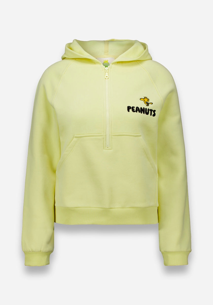 Der hellgelbe Princess Goes Hollywood Peanuts Hoodie hat einen halben Reißverschluss vorne, eine Kängurutasche, eine Kapuze und gerippte Bündchen am Saum. Eine kleine Woodstock-Grafik sitzt über dem fetten "PEANUTS"-Schriftzug auf der linken Brust für klassischen Komfort und Stil.
