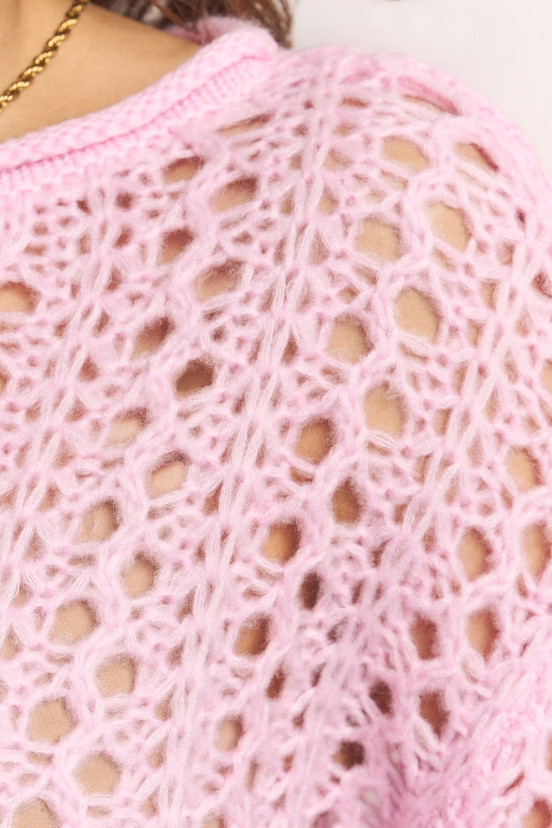 Nahaufnahme eines hellrosa Damenpullovers von Princess Goes Hollywood, locker gestrickt in einem Spitzenmuster. Der weiche Merino-Alpaka-Mix hebt die Maschen hervor. Am Hals der Trägerin ist eine dünne Goldkette zu sehen.