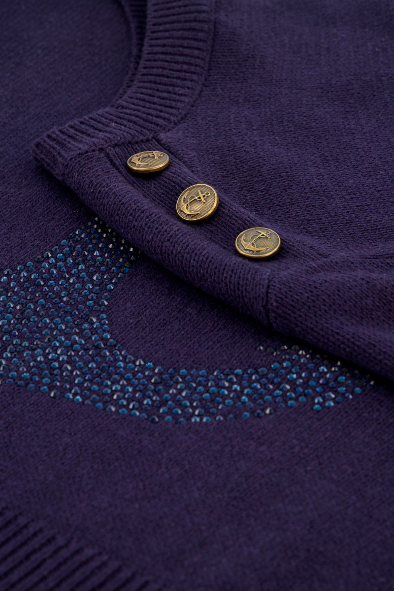 Eine Nahaufnahme des lilafarbenen Princess Goes Hollywood Baumwoll-Pullovers mit drei Knöpfen mit Metallic-Sterngravur. Blaue Strassverzierung bildet einen Halbmond unter dem geknöpften Kragen und hebt die sichtbare Strickstruktur hervor.
