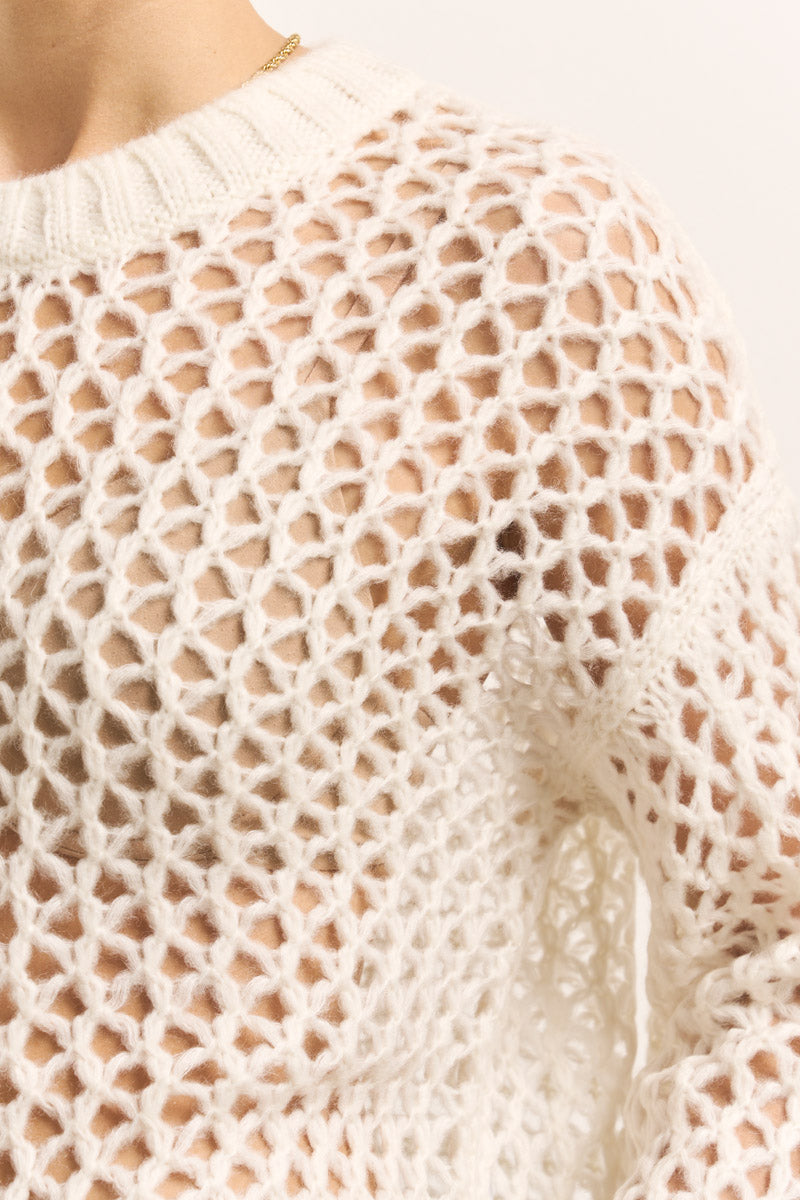 Nahaufnahme eines Princess Goes Hollywood Damen-Pullovers aus einem Merino-Alpaka-Mix mit klobigem Lochstrick-Wabenmuster, offen gestrickten Löchern, die Haut zeigen, geripptem Halsausschnitt und einer zarten Goldkette, die darunter sichtbar ist.