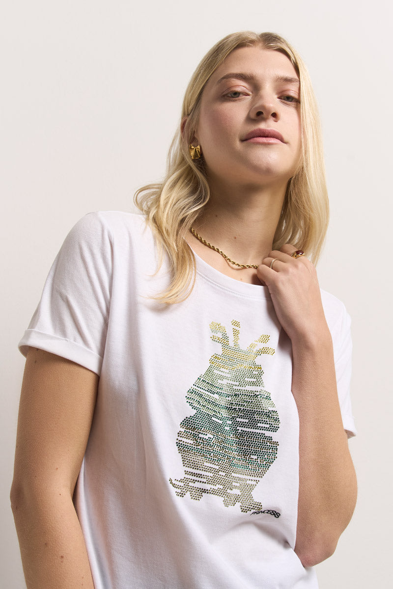 Eine junge Frau mit langen blonden Haaren modelliert ein Princess Goes Hollywood Baumwolle T-Shirt mit funkelndem, abstraktem Frosch-Print mit Strassverzierung. Dazu trägt sie goldene Ohrringe und eine Kettenhalskette und posiert selbstbewusst vor einem schlichten hellen Hintergrund.