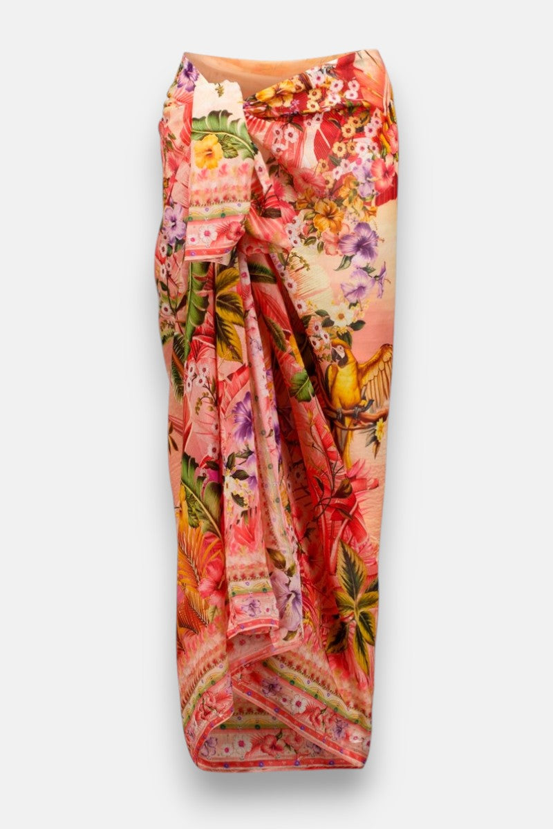 Princess Goes Hollywood präsentiert einen leuchtenden Pareo mit tropischem Aufdruck aus einer weichen Baumwoll-Seiden-Mischung, der an der Taille drapiert ist. Üppige Blumen, Blätter und Vögel in Pink, Orange, Gelb und Grün heben sich von einem pastellfarbenen Hintergrund ab.