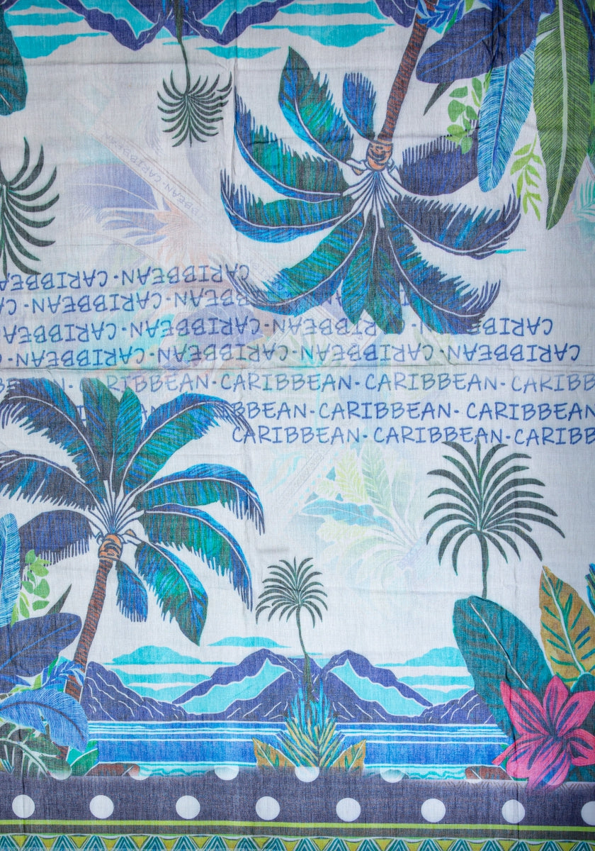 Der quadratische Schal Princess Goes Hollywood zeigt tropische Palmen, große Blätter, rosa Blumen und ein blaues Meer mit Hügeln. CARIBBEAN ist in der Mitte auf eine Baumwoll-Modal-Mischung mit St. Barth-Print gedruckt und sorgt für ein lebendiges Inselflair.