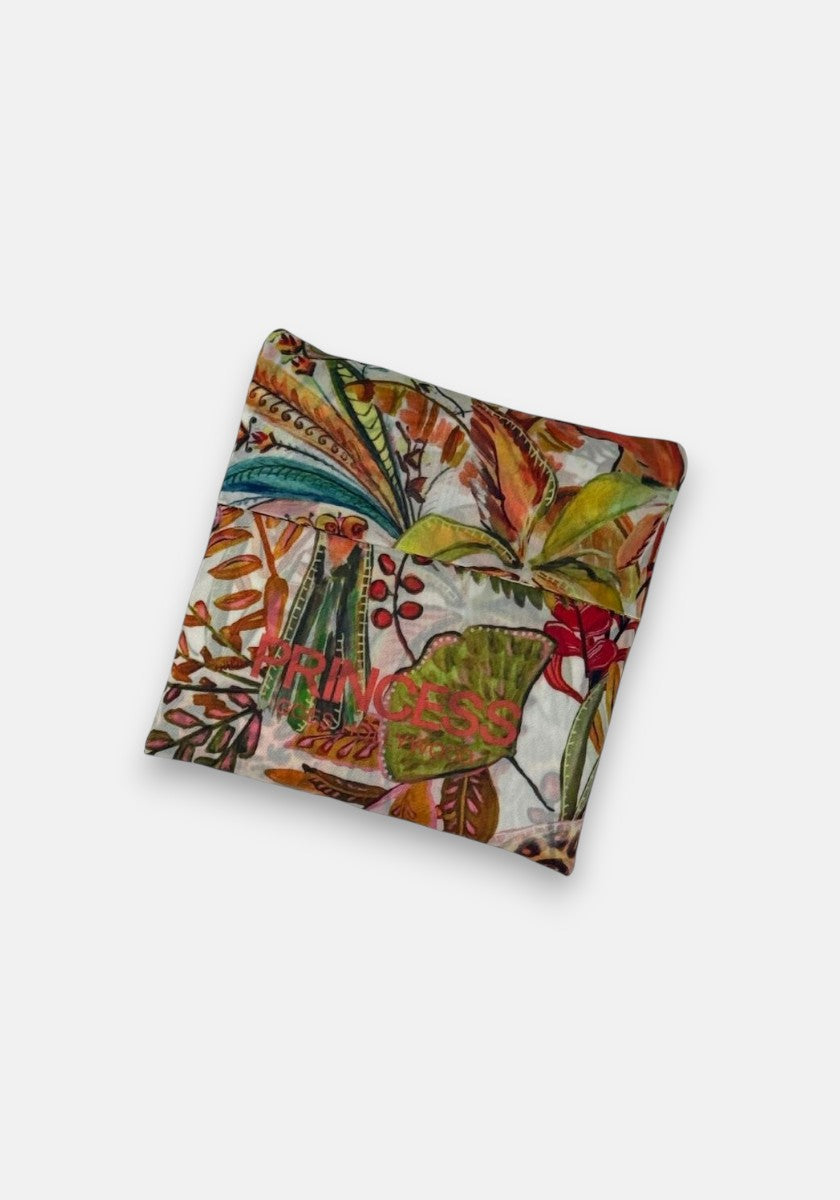 Eine gefaltete, farbenfrohe Einkaufstasche von Princess Goes Hollywood mit einem botanischen Muster aus grünen, orangen, gelben und roten Blättern und Blumen. Hergestellt aus recyceltem PET mit der Aufschrift "PRINCESS" in Rosa und Grün auf weißem Hintergrund.