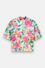 Das kurzärmelige Shirt Princess Goes Hollywood hat einen leuchtenden Blumenprint in Rosa, Gelb, Grün und Blau auf weißem, weichem Baumwollmischgewebe, einen geschnürten Halsausschnitt und eine kleine Brusttasche mit weißem Etikett.