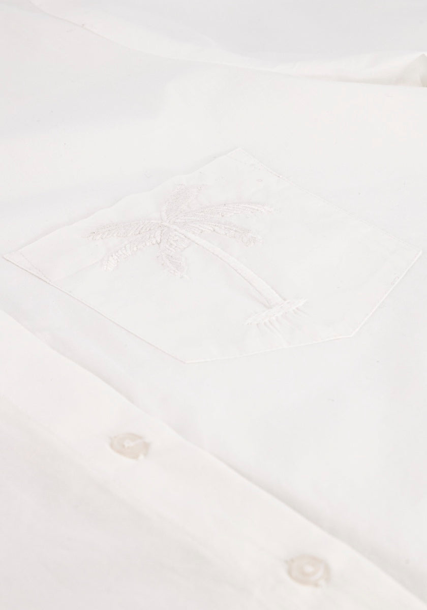 Nahaufnahme einer Princess Goes Hollywood Baumwollmix Hemdbluse für Damen mit einer Vordertasche, die mit Palmen-Stickerei in weißem Garn verziert ist. Weiße Knöpfe zieren die Knopfleiste und unterstreichen die klare, saubere Textur des Hemdes.