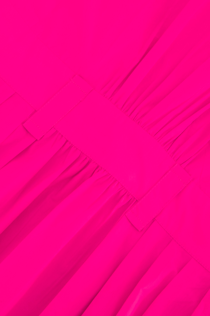 Nahaufnahme eines leuchtend rosafarbenen Baumwollstoffs mit gerafften Falten und zwei horizontalen Trägern, die diesem Midi-Hemdkleid von Princess Goes Hollywood Struktur verleihen. Das Material hat ein leicht glänzendes Finish.