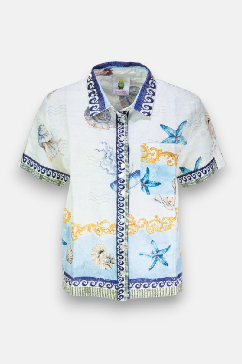 Kurzärmelige Bluse von Princess Goes Hollywood mit Muschel-Print, Seesternen und Wellen in Blau, Gelb und Beige auf Weiß. Dunkelblauer Kragen und Zierleiste mit weißen Swirl-Mustern runden das Design ab.