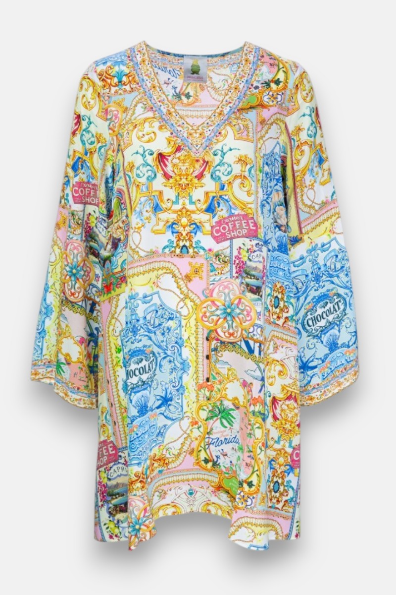 Ein leuchtendes Seidenblusenkleid von Princess Goes Hollywood mit langen Ärmeln und V-Ausschnitt, verziert mit blauem, rosa, gelbem und grünem Dolce Vita-Druck. "COFFEE SHOP" und "CHOCOLAT" heben das detaillierte Blumenmuster hervor.