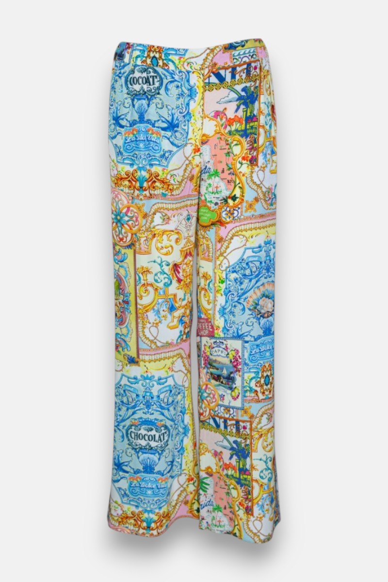 Seidenhose mit weitem Bein und hoher Taille von Princess Goes Hollywood, mit farbenfrohem Dolce Vita-Print mit barocken Mustern und alten Chocolat-Etiketten in Blau, Orange, Grün und Gelb auf einem strahlend weißen Hintergrund.