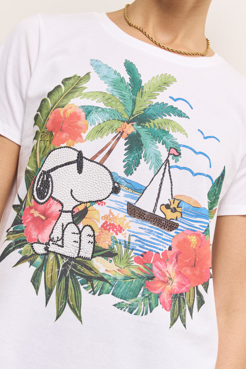 Eine Person trägt ein Princess Goes Hollywood Snoopy T-Shirt aus Baumwolle, verziert mit bunten tropischen Blumen, Palmen und einem Segelboot mit Woodstock. Eine goldene Kettenhalskette mit Strassdeko akzentuiert den sichtbaren Oberkörper und Hals.