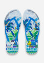Die Princess Goes Hollywood Flip-Flops haben blaue Riemen, ein tropisches Palmenblatt- und Vasenmotiv, Snoopy mit Sonnenbrille auf der linken Sandale, Woodstock auf der rechten und PRINCESS PEANUTS und ST. BARTH-Aufdrucke.