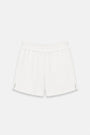 Die weißen Baumwollmusselin-Shorts „Princess Goes Hollywood“ für Damen verfügen über einen elastischen Bund, eine dezente Knitteroptik, kleine Seitenschlitze, eine lockere Passform sowie keine sichtbaren Taschen oder Verschlüsse. Abgebildet vor einem schlichten weißen Hintergrund. Limitierte Auflage.