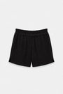 Eine schwarze Shorts aus Baumwollmusselin von Princess Goes Hollywood, gefertigt aus strukturiertem Stoff mit elastischem Bund und kurzen Schlitzen am Saum, flach auf einem hellgrauen Hintergrund präsentiert, für einen lässigen, bequemen Look.