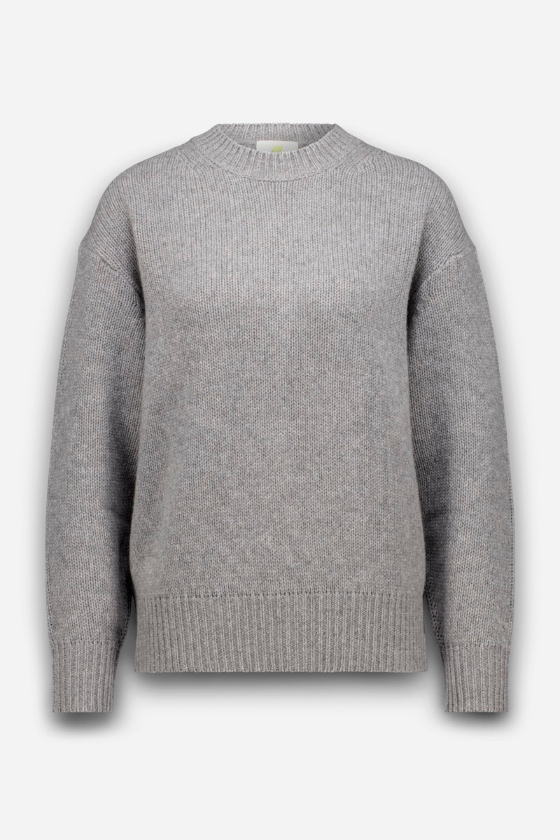 Ein schlichter, hellgrauer Strickpullover mit langen Ärmeln, Rundhalsausschnitt, gerippten Ärmelbündchen, Saum und Kragen, präsentiert vor weißem Hintergrund. Dieser weiche Pullover bietet zeitlosen Stil und Tragekomfort für den Alltag.