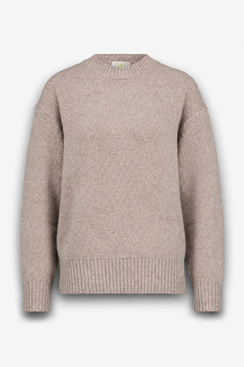 Beiger, langärmeliger Damenpullover aus weichem Kaschmir-Strick mit Rundhalsausschnitt, lockerer Passform und gerippten Details an Kragen, Bündchen und Saum. Der Pullover ist von vorne vor einem schlichten weißen Hintergrund zu sehen.