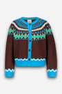 Eine braune Jacquard-Strickjacke mit blauen, weißen und grünen geometrischen Mustern. Die Strickjacke hat einen leuchtend blauen Kragen, eine Knopfleiste, Manschetten und einen Saum sowie drei dunkle Knöpfe auf der Vorderseite und lange Ärmel. Sie ist im klassischen Norweger-Stil gestaltet, wobei das Muster ein kreisförmiges Motiv um die Schultern bildet.