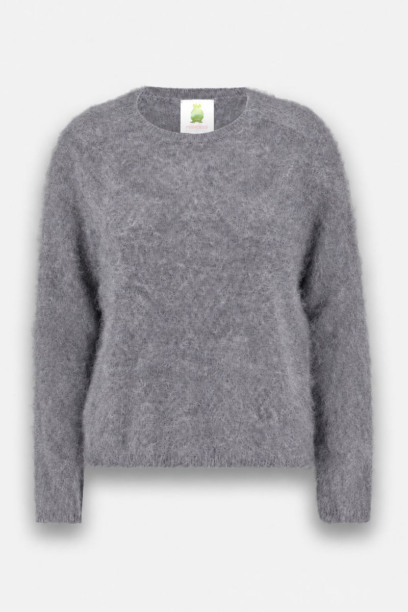 Ein weicher, flauschiger, grauer Langarmpullover mit Rundhalsausschnitt wird vor einem schlichten weißen Hintergrund präsentiert. Am inneren Kragen ist ein grünes Frosch-Logo zu sehen. Die Textur des Pullovers aus gebürsteter Wolle wirkt gemütlich und plüschig.