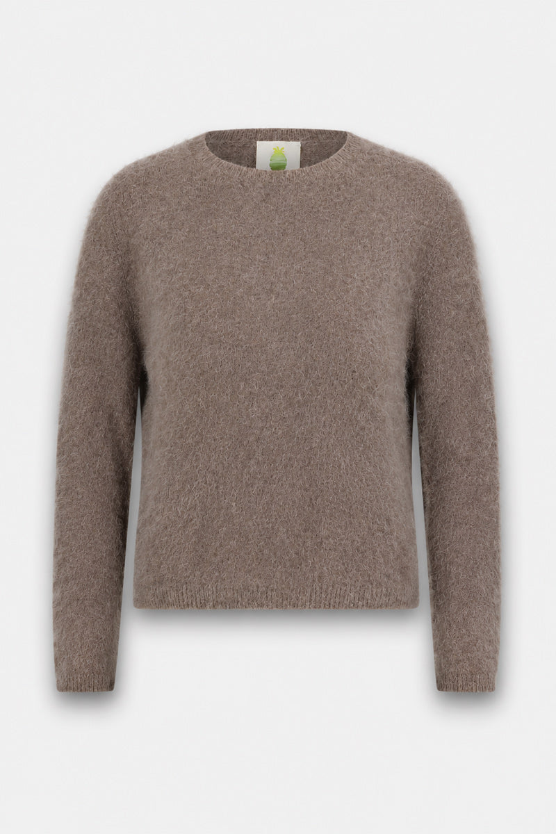 Ein brauner, langärmeliger, flauschiger Pullover mit klassischem Rundhalsausschnitt wird vor einem schlichten weißen Hintergrund präsentiert. Der weiche, flauschige Stoff vermittelt ein Gefühl von Komfort, und die Passform wirkt locker. An der Innenseite des Nackens ist ein grünes Etikett zu sehen.