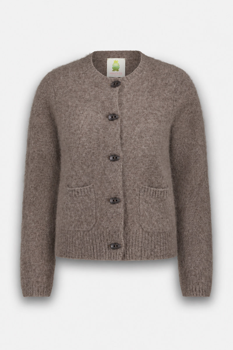 Eine flauschige, hellbraune Strickjacke aus gebürsteter Wolle mit fünf dunklen Knöpfen, zwei Vordertaschen, gerippten Bündchen und Saum sowie einem Rundhalsausschnitt. Diese flauschige Strickjacke wird vor einem weißen Hintergrund präsentiert, wobei das Etikett im Nackenbereich sichtbar ist.