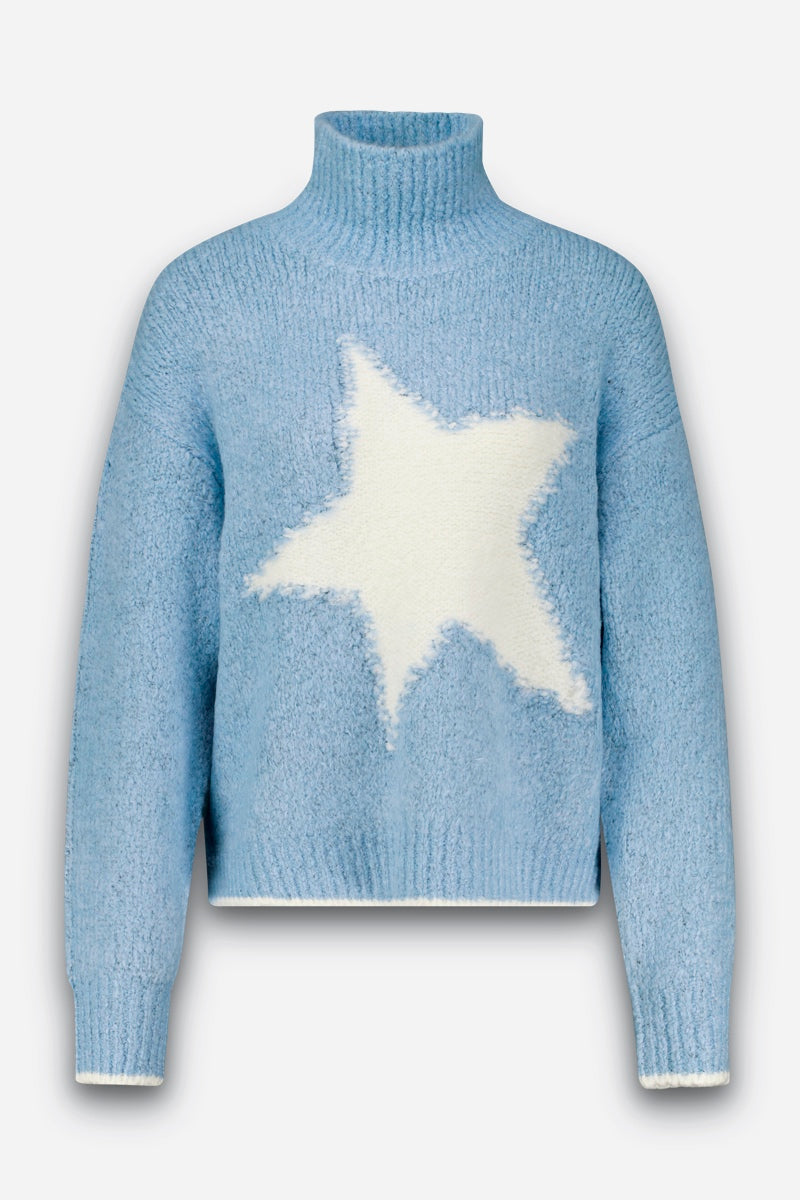 Hellblauer, flauschiger Strickpullover mit Stehkragen, langen Ärmeln und lockerer Passform. Auf der Vorderseite befindet sich in der Mitte ein großes, flauschiges weißes Sternmotiv. Dieser Grobstrickpullover wirkt weich und kuschelig und verfügt über gerippte Bündchen, Saum und Kragen. Der Hintergrund ist schlicht weiß.