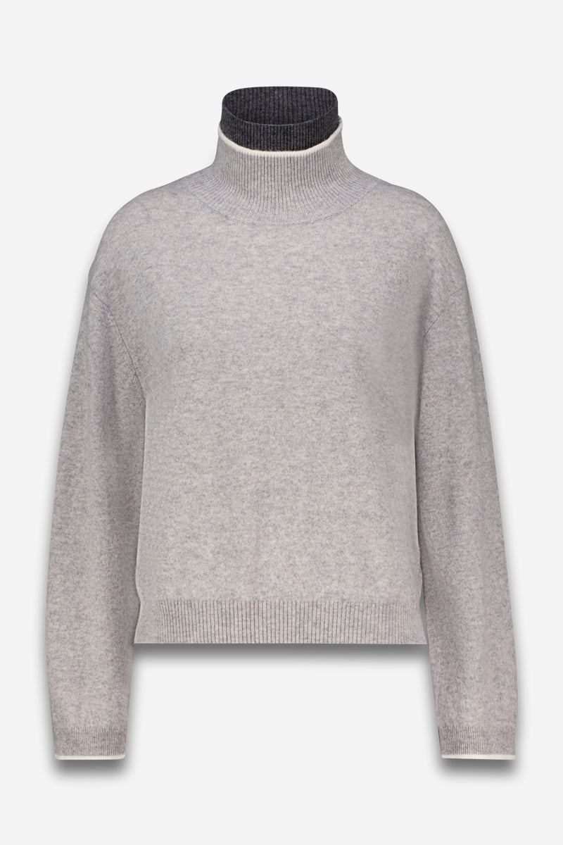 Ein hellgrauer Strickpullover mit langen Ärmeln und einem hohen, gerippten Stehkragen. Die Innenseite des Kragens ist dunkel anthrazitgrau, und das Kleidungsstück hat eine verkürzte Passform mit gerippten Bündchen und Saum.