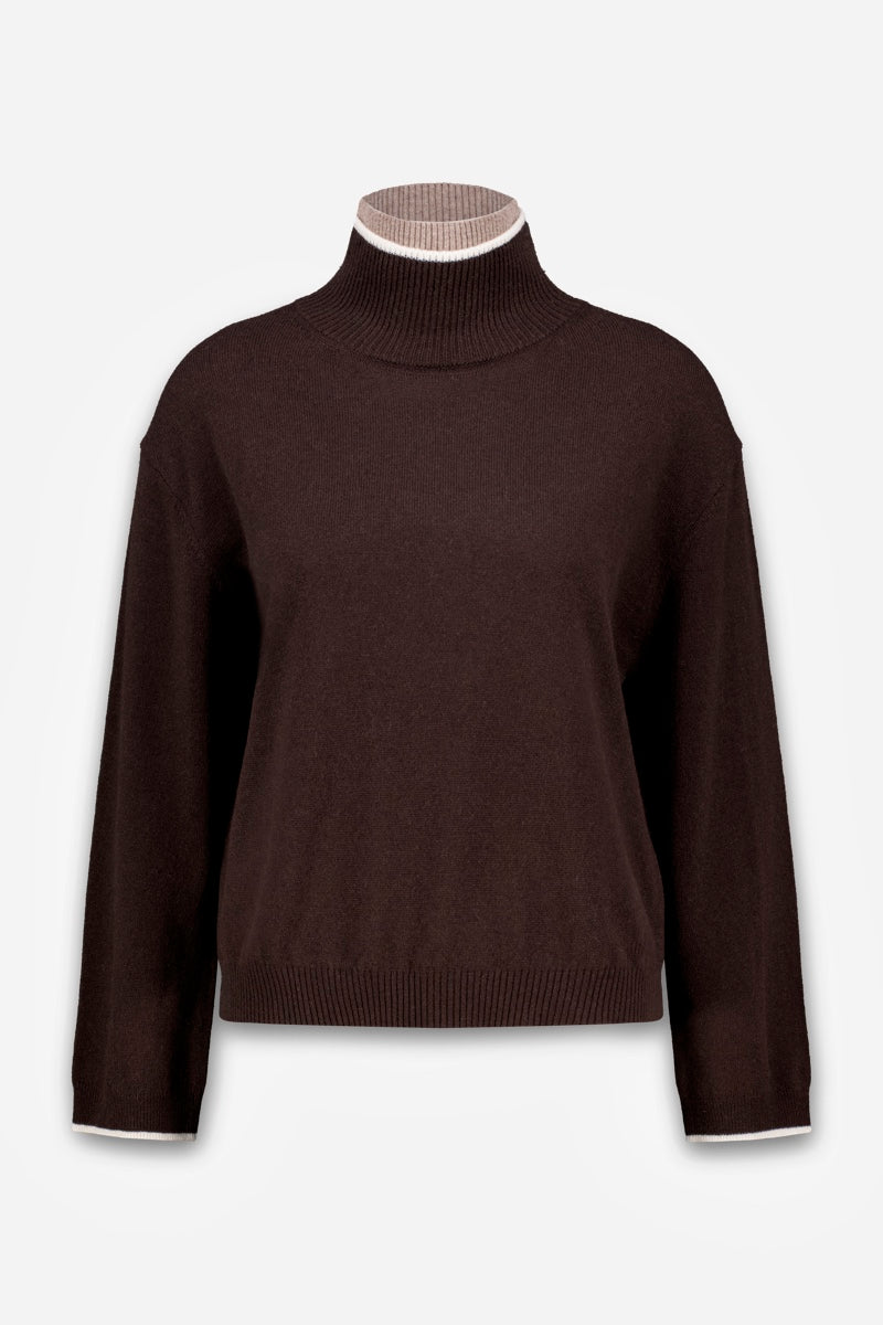 Ein dunkelbrauner Strickpullover mit Stehkragen und langen Ärmeln. Der Halsausschnitt und die Ärmelbündchen sind mit einem schmalen, weiß-hellbraun gestreiften Detail verziert.