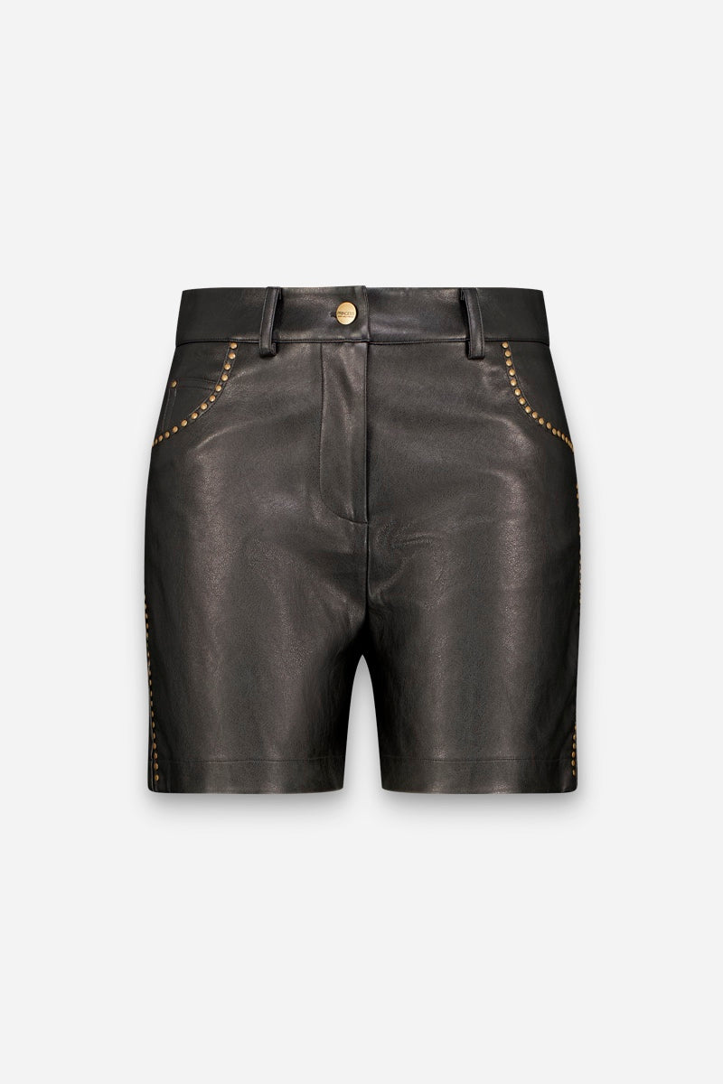Vorderansicht von schwarzen veganen Ledershorts mit goldener Nietenverzierung entlang der geschwungenen Vordertaschen und Seitennähte, einem Hosenschlitz vorne mit goldenem Knopfverschluss sowie Gürtelschlaufen. Die Shorts zeichnen sich durch eine glatte Textur und eine taillierte Passform vor einem schlichten weißen Hintergrund aus.