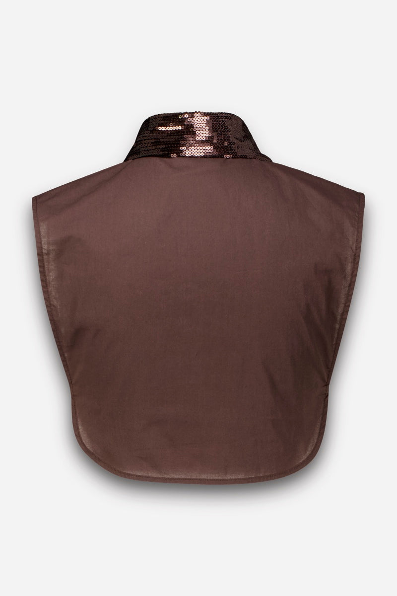 Ein braunes Stofflätzchen oder Krageneinsatz, ideal für einen schicken Blusen-Look oder lässige Lagenlooks, ist oben mit einem glänzenden, dunkelbraunen Paillettenband verziert. Die rechteckige Form hat abgerundete Unterkanten und wird vor einem schlichten weißen Hintergrund gezeigt, wobei die Rückseite des Artikels zu sehen ist.