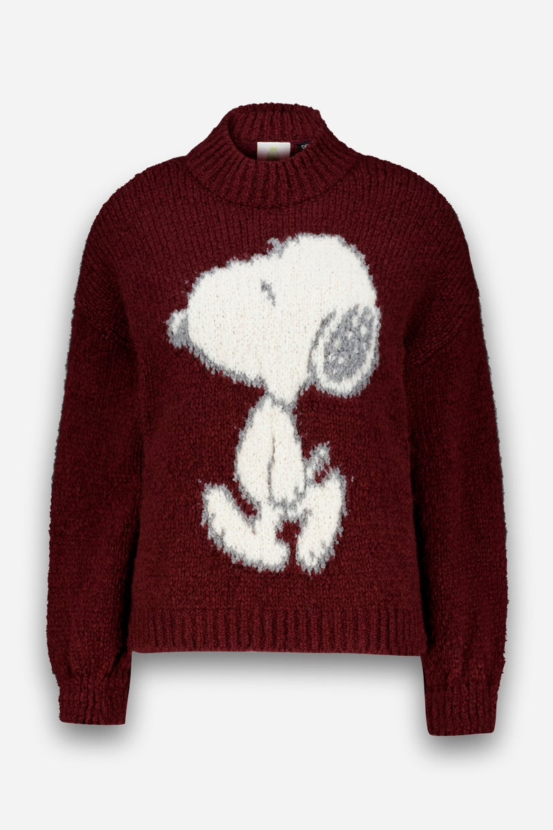 Ein kastanienbrauner Grobstrickpullover mit einem großen, flauschigen weißen Snoopy-Motiv, das den Comic-Hund Snoopy im Profil zeigt. Der Pullover hat einen gerippten, hohen Ausschnitt, lange Ärmel sowie gerippte Bündchen und einen gerippten Saum. Er ist aus einer kuscheligen Wolle-Mohair-Mischung gefertigt und verbindet Wärme mit verspieltem Charme. Der Hintergrund ist schlicht weiß.